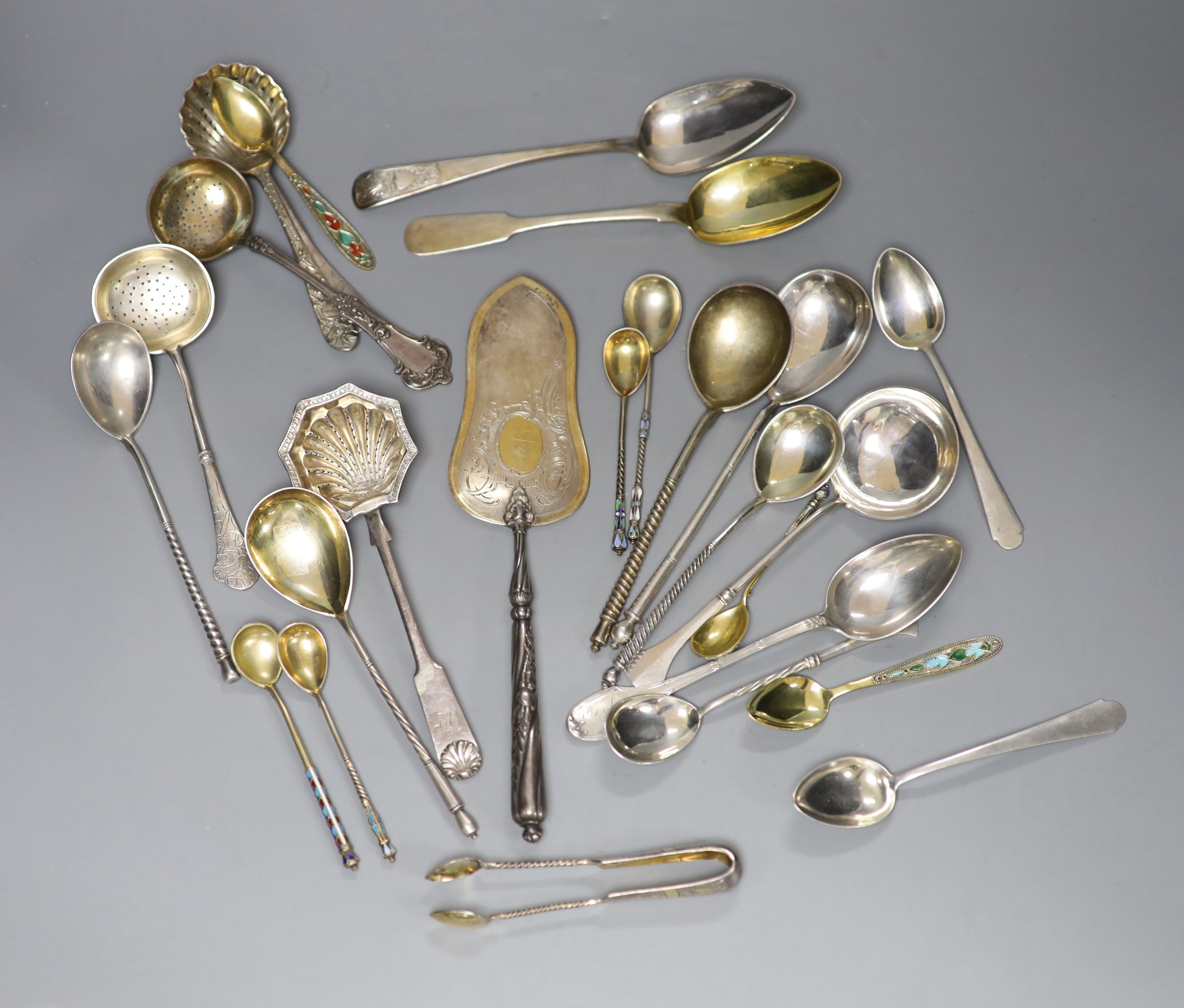 A late 19th century Russian 84 zolotnik tea strainer, a Russian cake slice and sugar sifter and a group of other Russian flatware including enamelled teaspoons